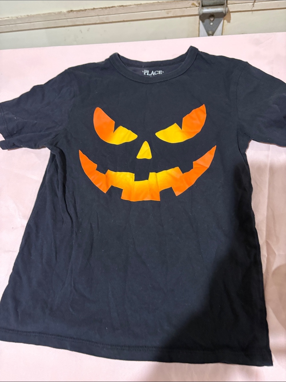 Place Black Tee with Orange Jack-O'-Lantern Face